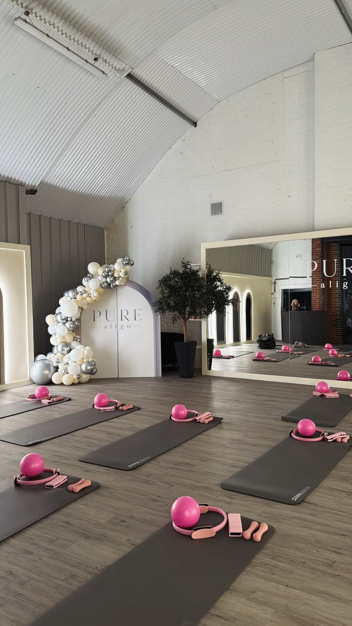 Mats and pink Pilates equipment laid out ready for class